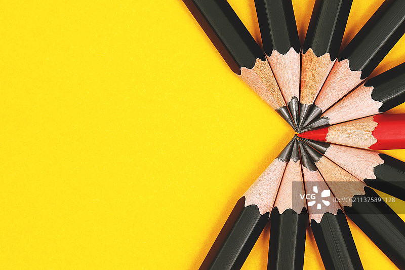 教育：学生使用彩色铅笔，从高角度看黄色背景上的铅笔图片素材