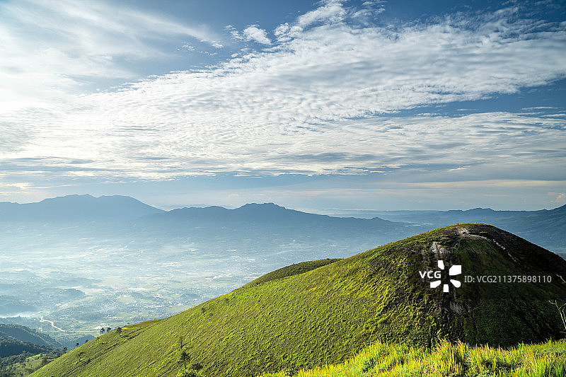 印度尼西亚山脉与广阔的绿色草地图片素材