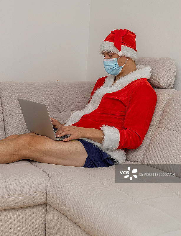 打扮成圣诞老人，用笔记本电脑，没穿裤子图片素材