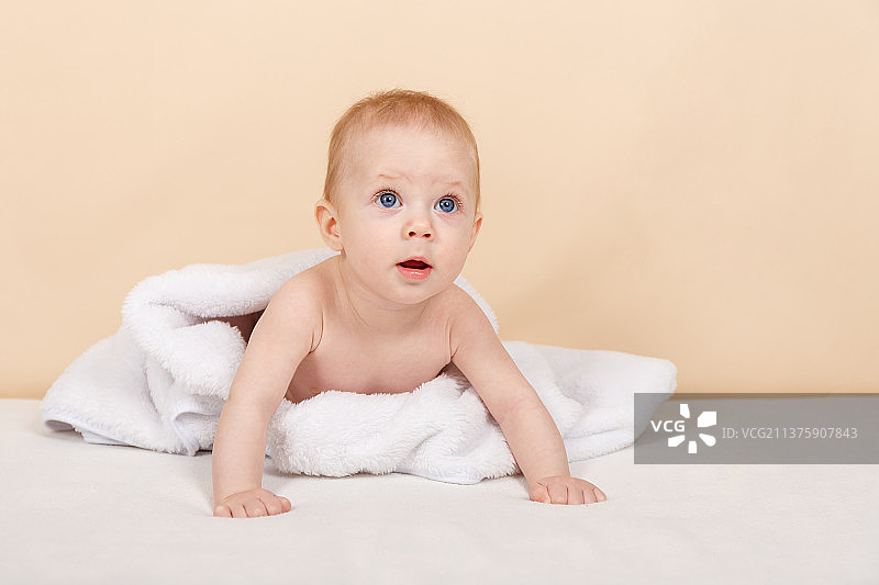 白色毛巾或毯子上可爱的婴儿俯卧特写肖像图片素材