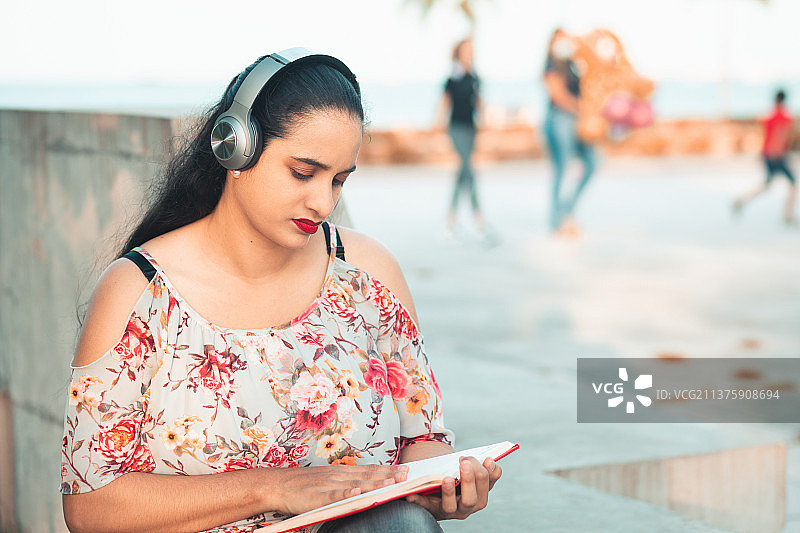 戴着耳机听音乐的西班牙裔女孩，巴拿马图片素材