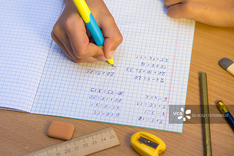 特写镜头：学生用圆珠笔在笔记本上写字图片素材