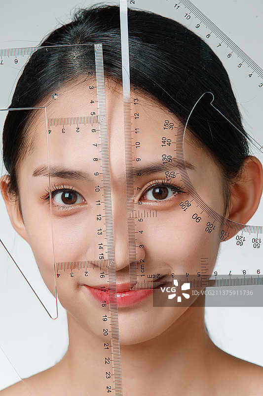 做面部整形的青年女人拿着尺子图片素材