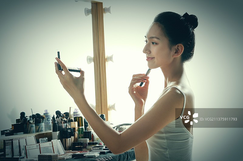 年轻女人在化妆间里化妆图片素材
