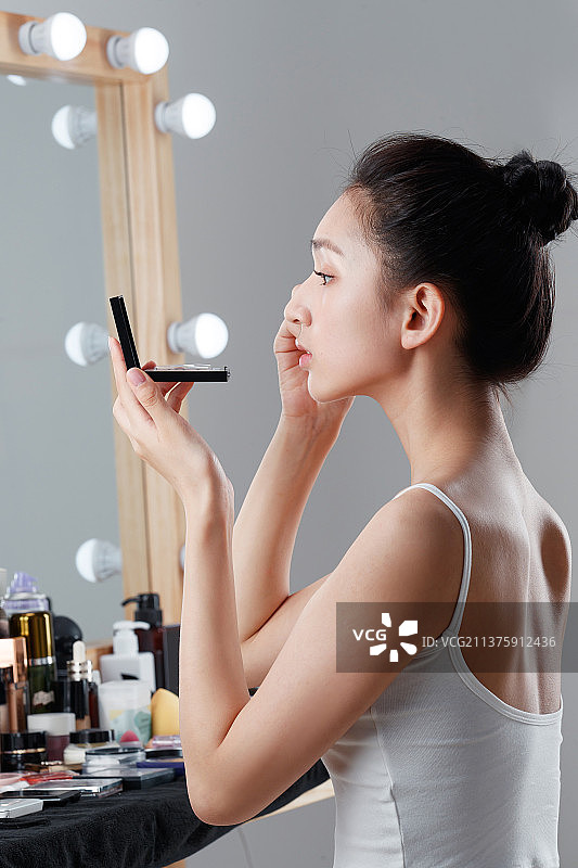 年轻女人在化妆间里化妆图片素材