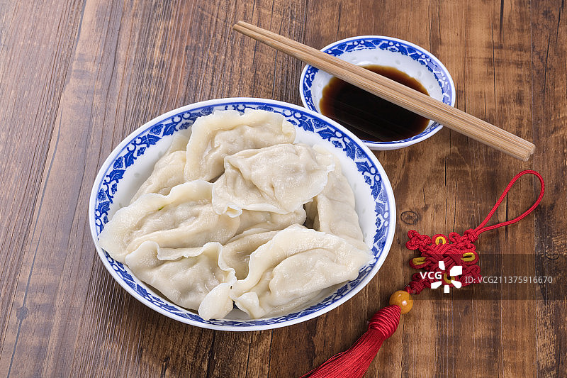一盘饺与醋碟筷子中国结特写木桌面背景图片素材
