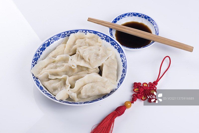 一盘饺与醋碟筷子中国结特写木桌面背景图片素材