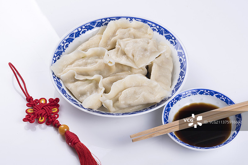 一盘饺与醋碟筷子中国结特写木桌面背景图片素材