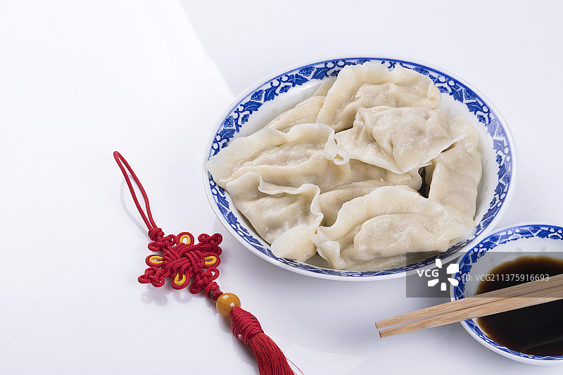 一盘饺与醋碟筷子中国结特写木桌面背景图片素材