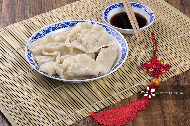 一盘饺与醋碟筷子中国结特写木桌面背景图片素材