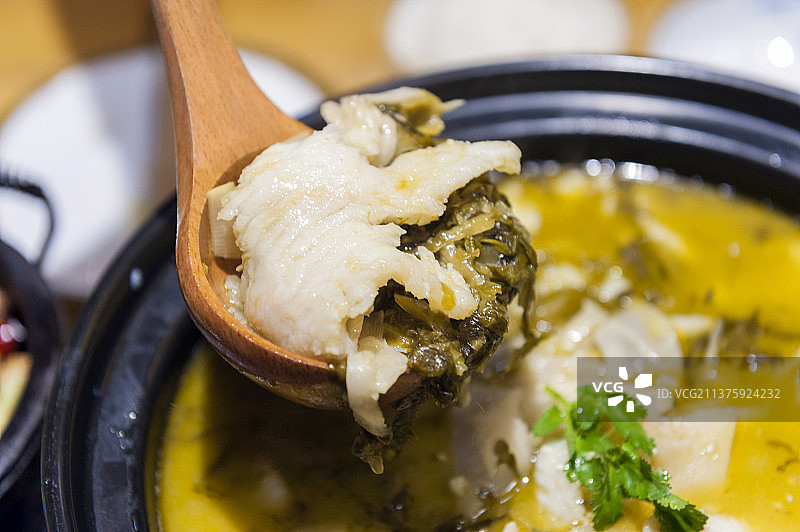 一盆酸菜鱼摆放在木桌面背景上图片素材