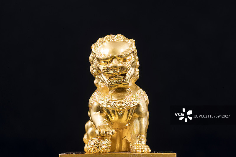 铜制金色狮子特写黑色背景图片素材