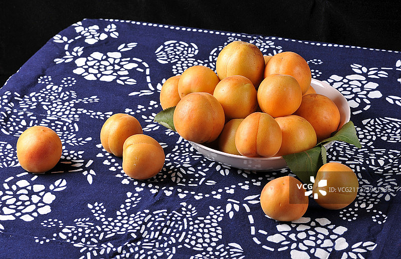 一盘杏摆放在蓝印花布上特写图片素材