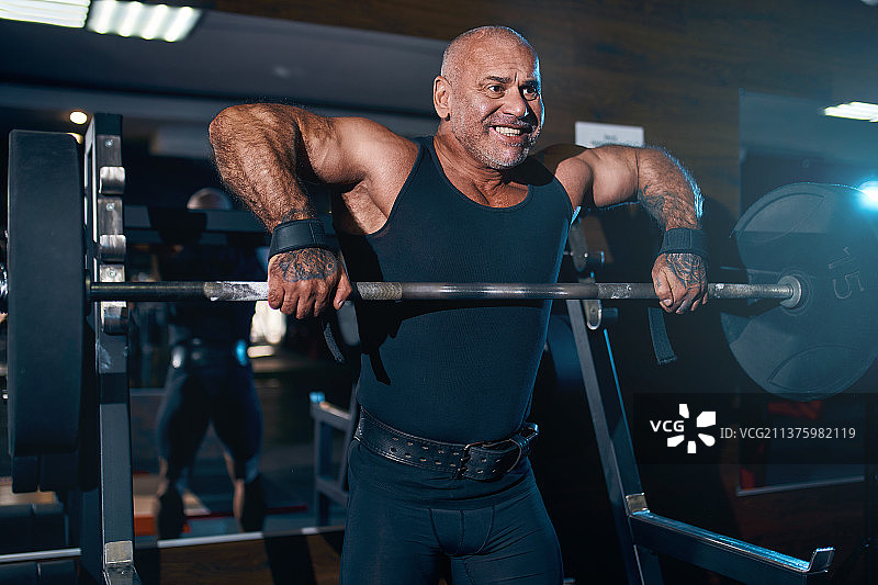 年长的男人在明亮的工作室健身房进行高强度锻炼图片素材