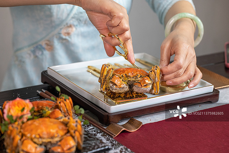 一个中年女人剥蟹壳吃蟹肉图片素材