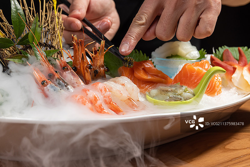 日式料理厨师制作刺身拼盘套餐图片素材