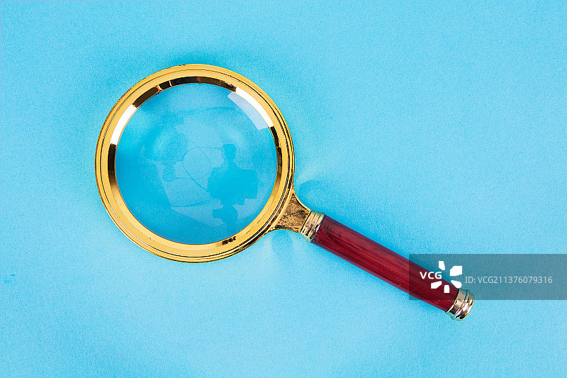 蓝色背景上的放大镜图片素材