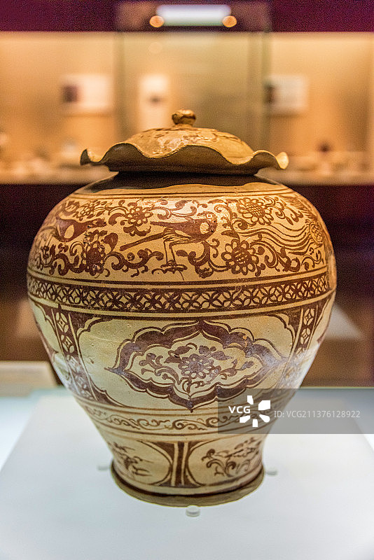 中国广州广东省博物馆馆藏元代雷州窑釉下褐彩凤鸟纹荷叶盖罐图片素材