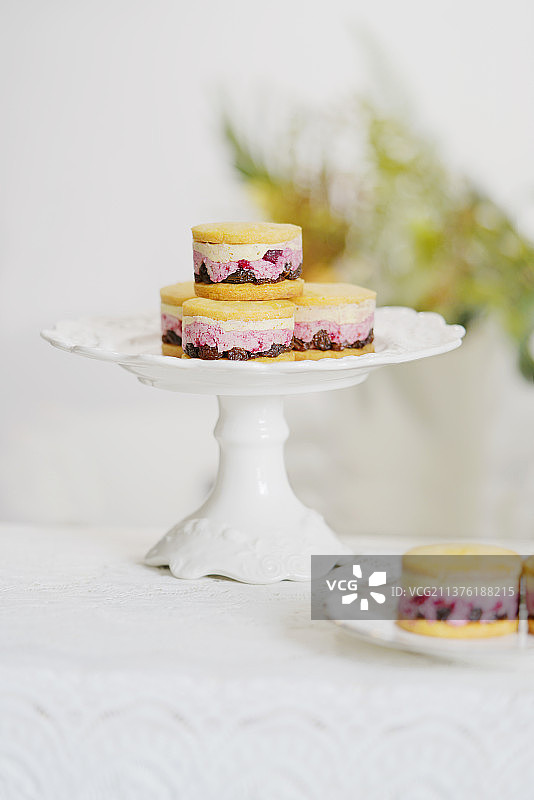 高托盘里的开心果树莓夹心曲奇图片素材