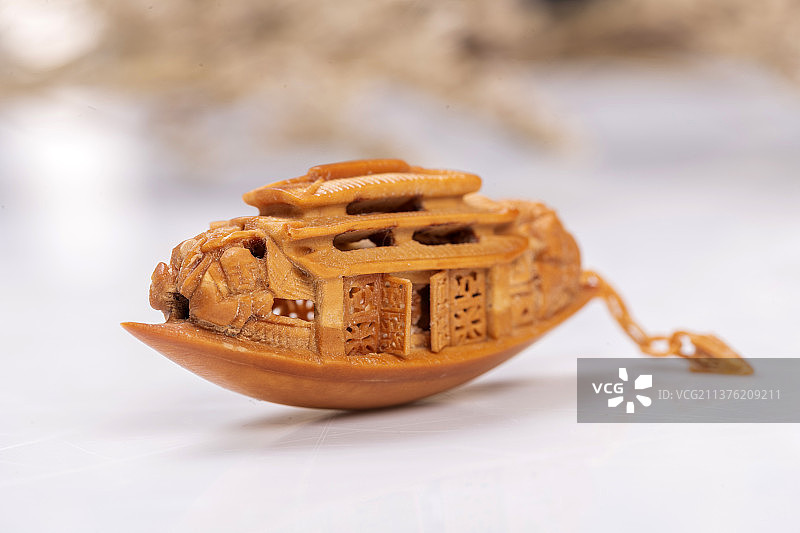 手持橄榄核雕核舟记及盘龙橄榄核特写图片素材