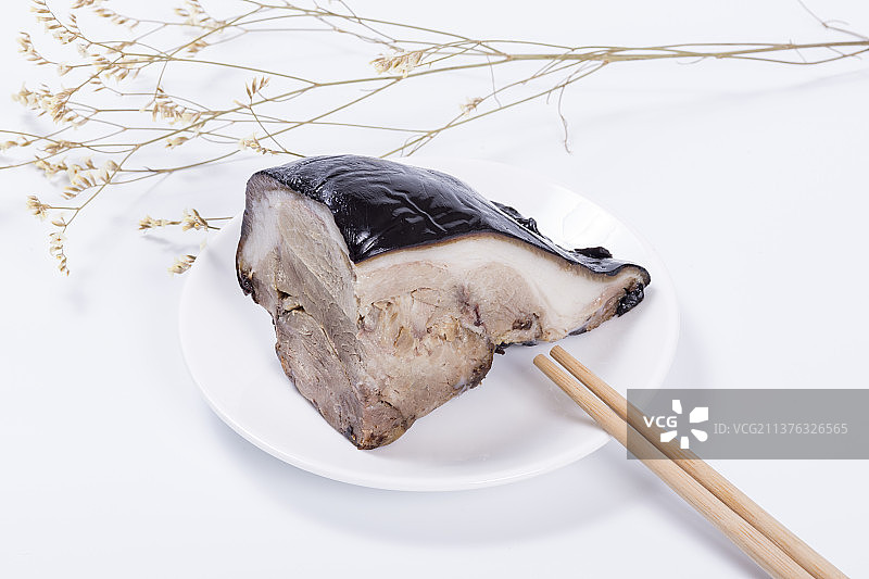 一盘酱猪肘子摆放在木桌面上特写图片素材