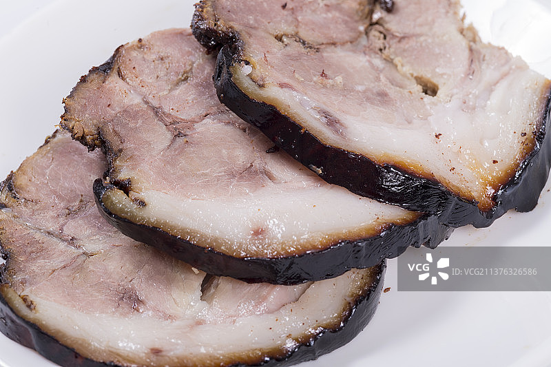 一盘酱猪肘子摆放在木桌面上特写图片素材