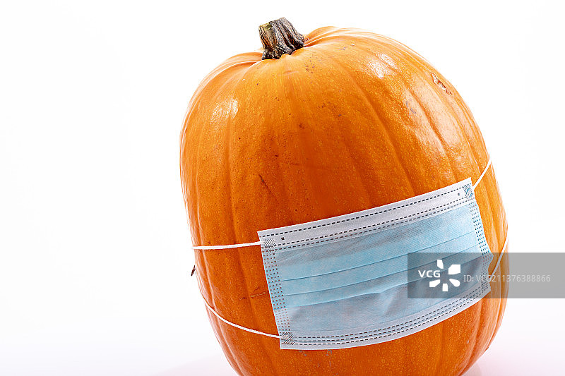 白色背景上戴着面具的万圣节南瓜图片素材