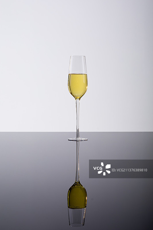 香槟笛特写，玻璃桌上的倒影，白色背景饮品图片素材
