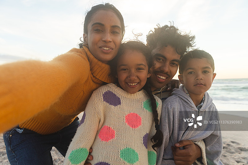 混血 महिला与家人在海滩日落时自拍图片素材