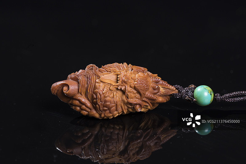 手持橄榄核雕盘龙橄榄核特写图片素材