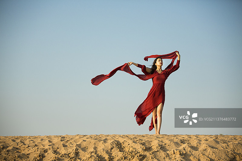 沙漠上穿着礼服跳舞的美女模特图片素材