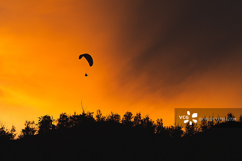 黄昏下空中的滑翔伞图片素材