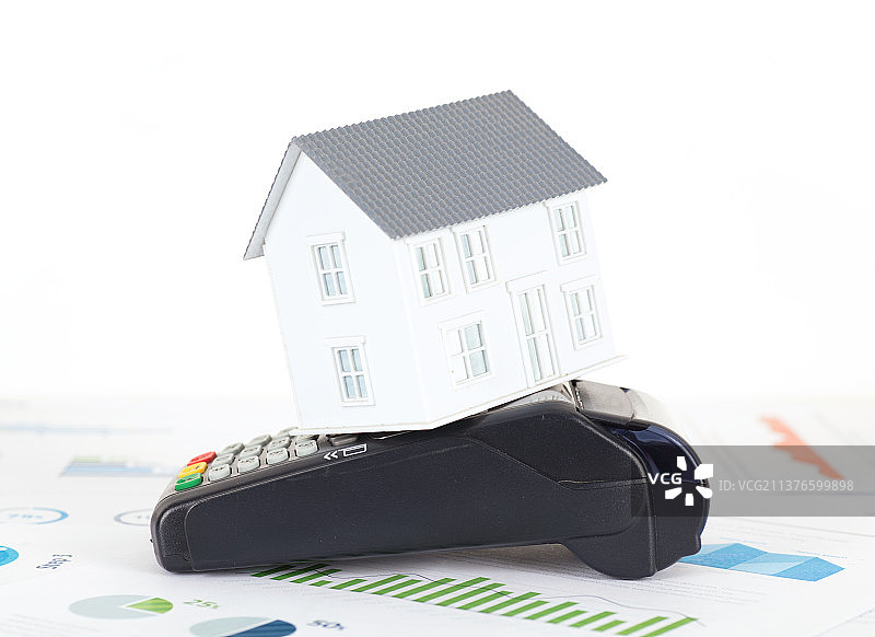 金融图表上的房子模型和pos机图片素材