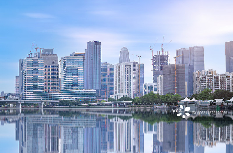 江边的现代化建筑群落，包含集团公司总部和在建的建筑图片素材