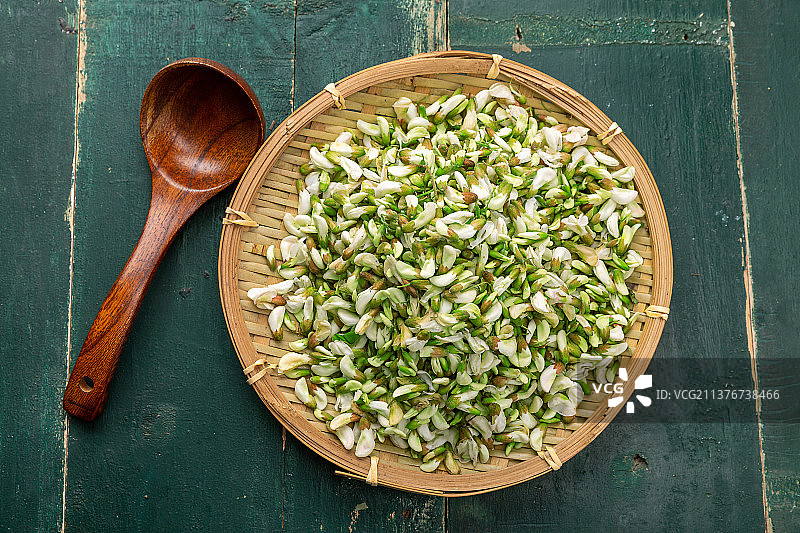 装在竹筐里的野生洋槐花花骨朵图片素材