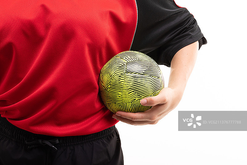 对着白色背景拿着黄色球的年轻白人女子手球运动员腰部特写图片素材