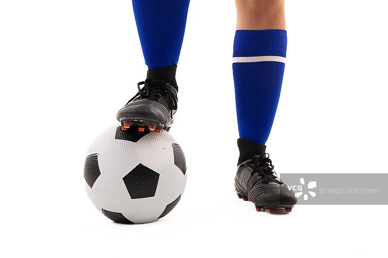 年轻女运动员下半身，脚踩足球图片素材