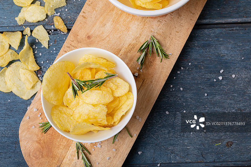 碗中薯片特写，木桌上有迷迭香图片素材