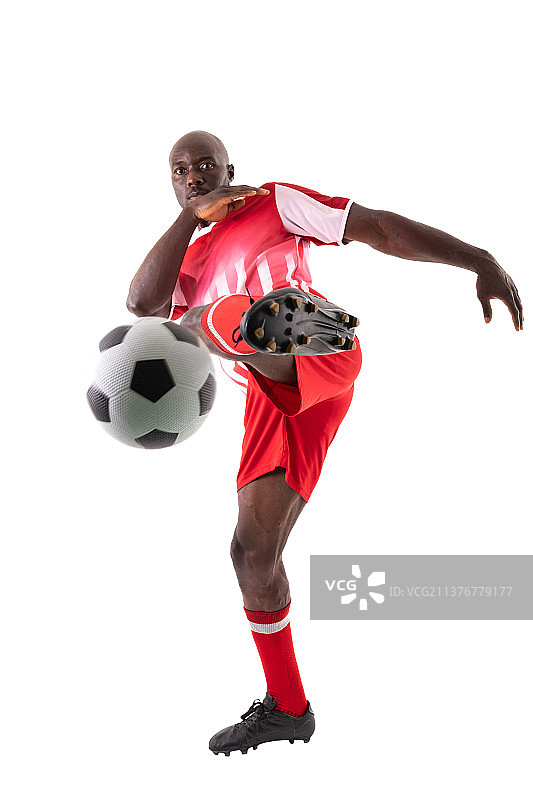 自信的非裔美国男性运动员在白色背景下踢足球图片素材