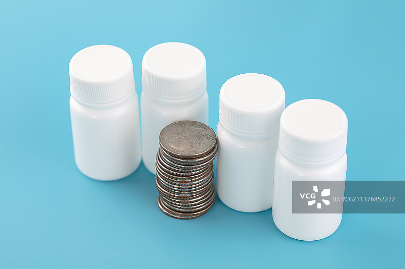 白药瓶和美元硬币在蓝背景上图片素材
