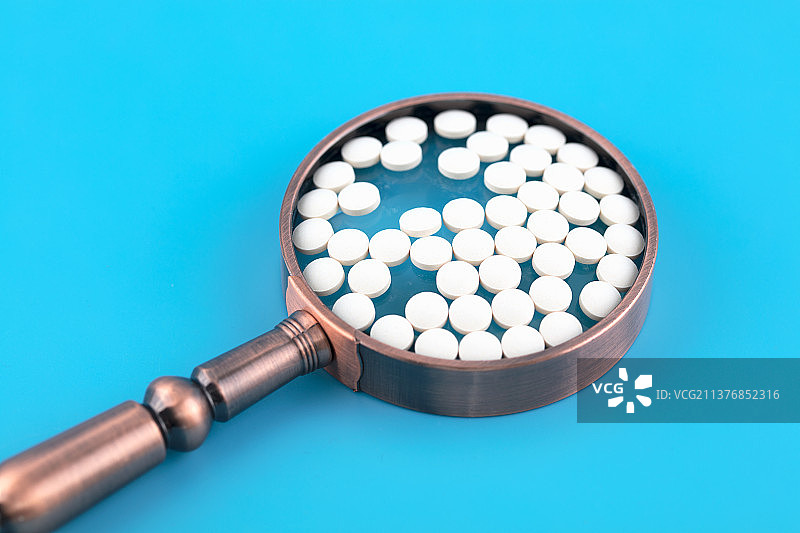 放大镜上的白色药丸图片素材