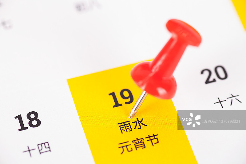 台历上被大头钉标注的中国24节气之一的雨水和传统节日元宵节图片素材