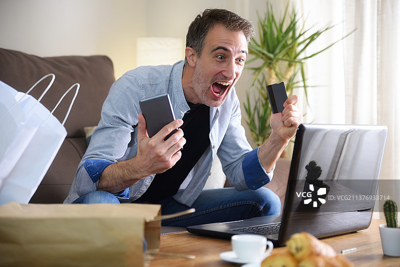 兴奋的男人在家成功网购图片素材