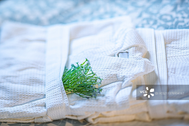 酒店床上折叠的白色浴袍特写图片素材