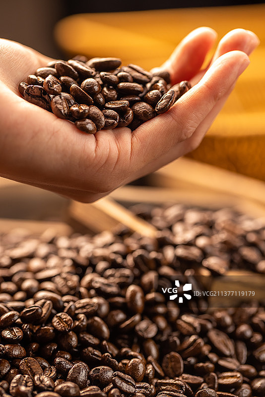 手拿咖啡豆抛洒掉落图片素材