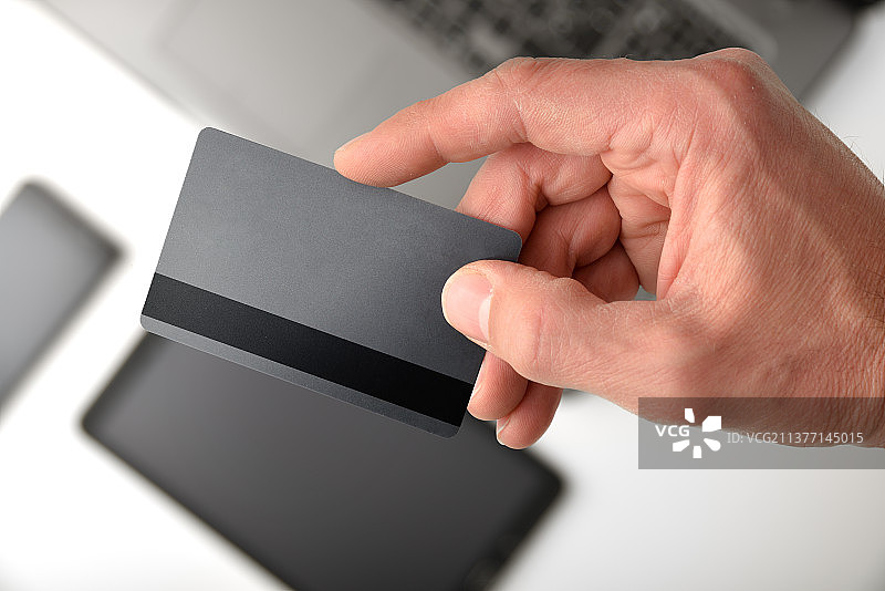 电子支付概念，手持信用卡和设备图片素材