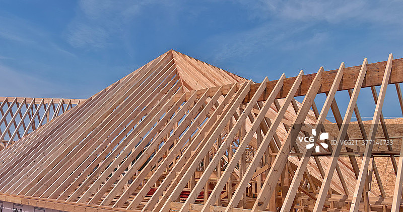新建房屋中正在建造的木制屋顶桁架框架图片素材