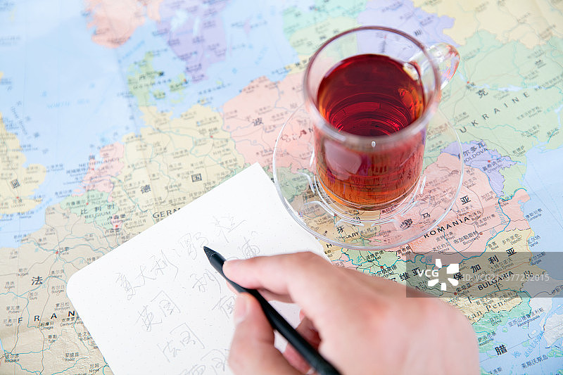 在一幅放着一杯红茶的地图上做旅游计划图片素材