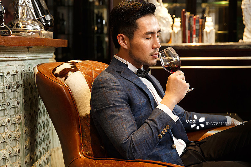 青年男人拿着红葡萄酒杯图片素材