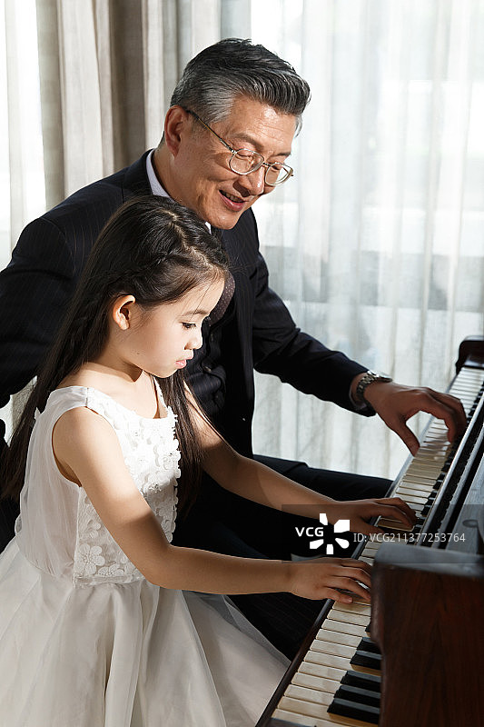 祖父和孙女一起弹钢琴图片素材